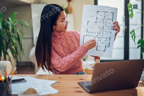 Preview: Vietnamese Asian woman using laptop for a video call while working at home