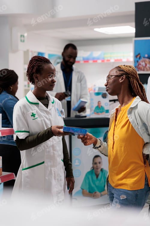 Preview: African american pharmacist giving customer backache medication in drugstore