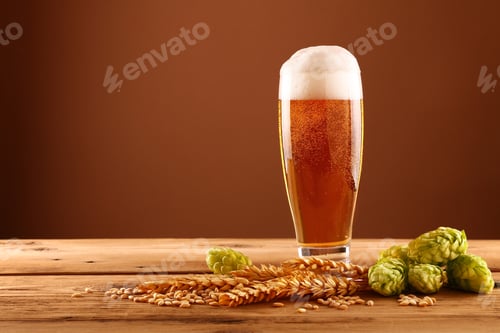 Preview: Close up beer glass, hops and barley over brown
