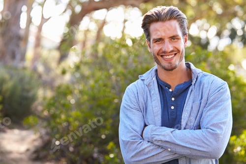 Preview: Portrait of young white man smiling arms crossed outdoors