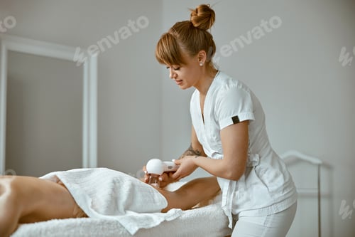 Vista previa: specialist is doing relaxing body massage for beautiful caucasian lady at minimalistic spa salon
