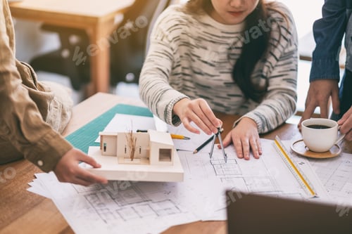 Preview: An architect using compass to draw and measure shop drawing in office