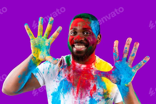 Preview: latin brazilian male in white cotton t-shirt with colorful paint of face laughing studio