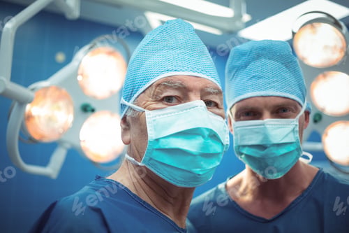 Preview: Portrait of male surgeons wearing surgical mask in operation theater