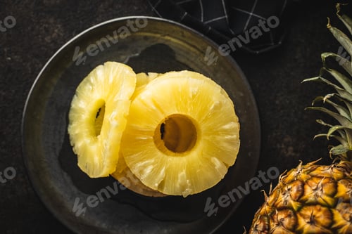 Preview: Canned sliced pineapple fruit on plate.