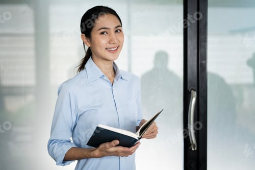 Preview: Confident asian business woman, office worker in casual wear, holding notebook, standing in office