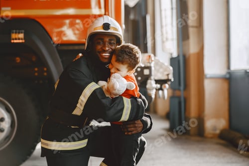 Preview: Portrait of a firefighter standing in front of a fire engine