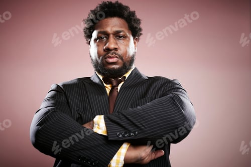 Preview: Studio portrait of mid adult businessman with arms folded
