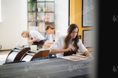 Preview: Three women in aprons working at pottery, kneading clay and making earthenware at workshop