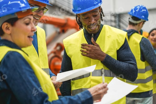 Preview: Industrial engineers working inside robotic factory - Focus on african man face