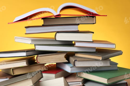 Preview: Many different books against yellow background, closeup
