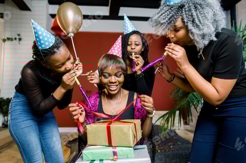 Preview: A beautiful smiling African girl opens a present at her birthday party