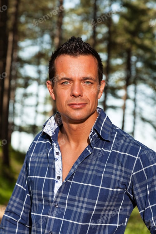 Preview: Good Looking Lumberjack Man With Blue Shirt In Forest.