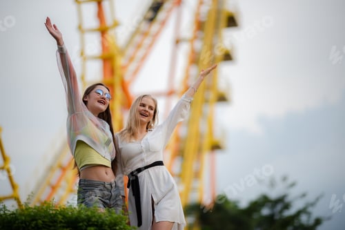 Visualização: jovem mulher se divertindo e feliz sorrindo juntas no parque tema de diversões ao ar livre