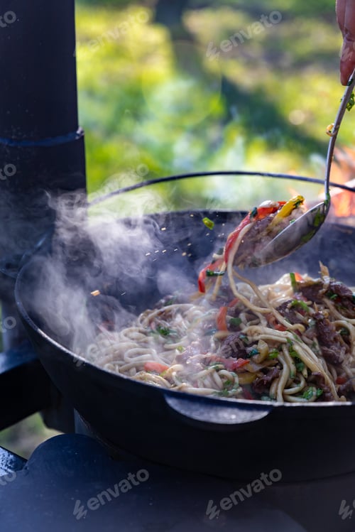Preview: The process of cooking lagman in a cauldron on an open fire.