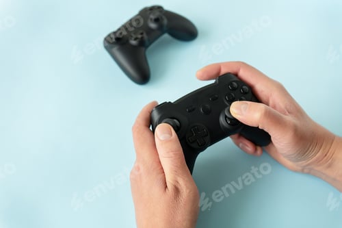Preview: Isolated hands on a blue background that hold a joystick. Gamer, game, recreation, competition.