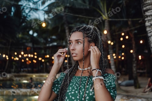 Preview: Woman wearing earphones looking away in bali hotel