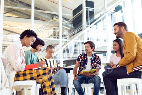 Preview: Low angle view of diverse Business people sitting together and having group discussion in office