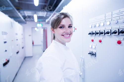 Preview: Portrait of young female scientist next machine in technical room