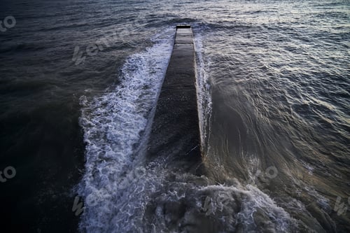 Preview: Landscape with a stone pier and raging waves in the sea.