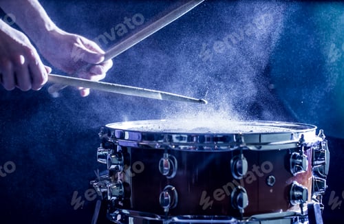 Preview: Man plays musical percussion instrument with sticks close up.