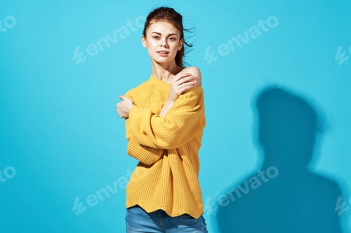 Preview: woman in yellow sweater fashion hairstyle casual wear Studio cropped view blue background