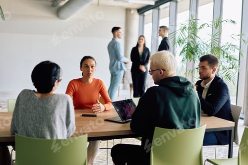 Preview: A diverse team of business professionals engaged in a discussion around a conference table in an