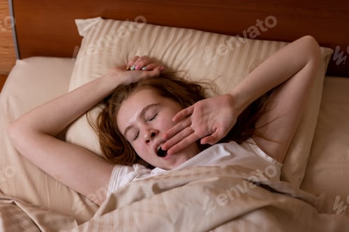 Preview: Young teen girl lies on the bed and yawns