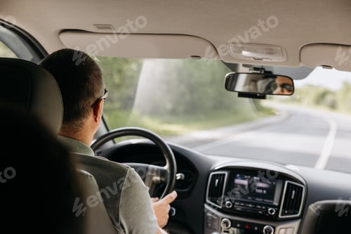 Preview: Young man holding steering wheel while driving car. Road trip adventure