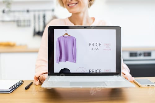 Preview: Happy woman displaying online clothes shopping on laptop screen