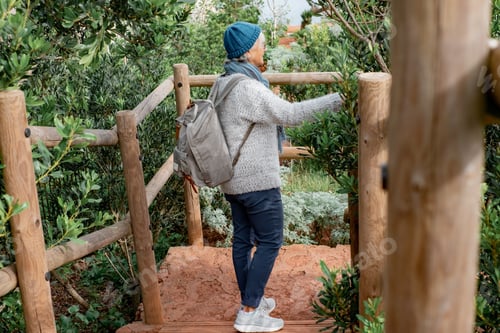 Preview: Senior caucasian woman on hiking trip with backpack enjoying freedom and nature