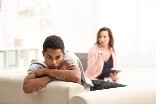 Vista previa: Psychotherapist working with teenage African-American boy in office