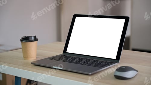 Preview: Blank screen laptop with brown take away coffee mug on the table in the office.
