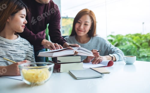 Preview: Group of young students tutoring and catching up workbook together