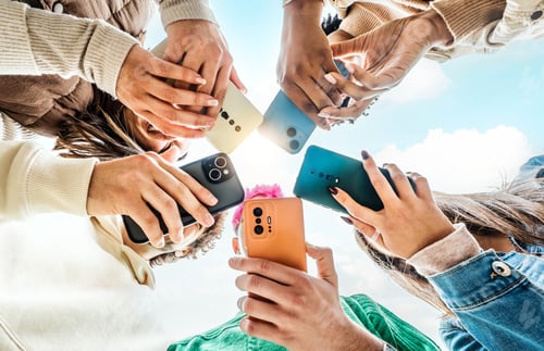 Preview: Group of young people using smart mobile phone device outside
