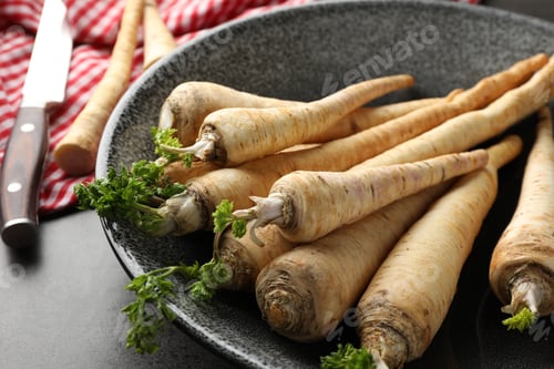 Preview: Parsley roots with leaves and knife on black table, closeup