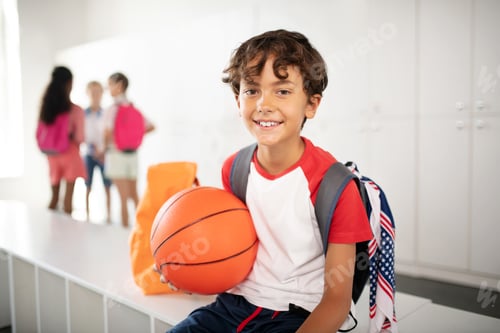 Preview: Cheerful schoolboy feeling excited before PE class