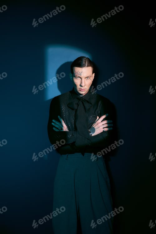 Preview: Stylish young man exudes confidence in modern urban setting with dramatic lighting