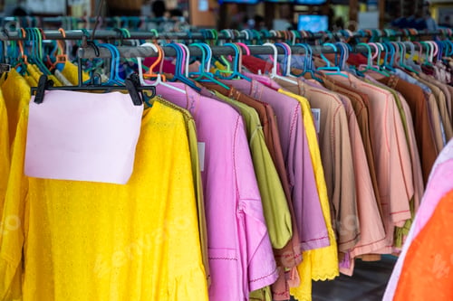 Preview: Colorful clothes of cotton fabric hanging on rail in store