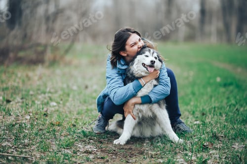 Preview: Young woman play with husky dog for a walk in spring forest. laughing having fun, happy with pet