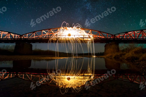 Preview: Light painting art concept. Spinning steel wool in abstract circle, firework showers