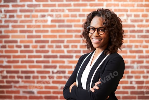 Preview: Portrait Of Smiling Businesswoman Wearing Glasses Standing Against Brick Wall In Modern Office
