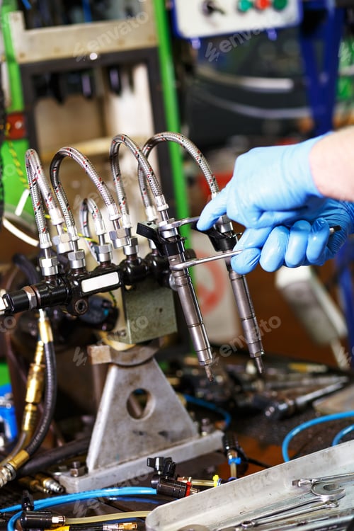Preview: Professional mechanic testing diesel injector in his workshop.