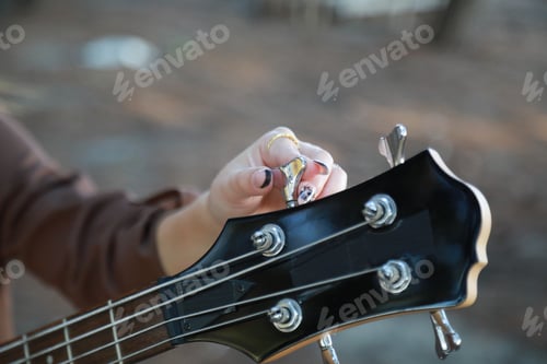 Preview: Girl Adjust Handles To Tune Bass Musical Instrument In The Park