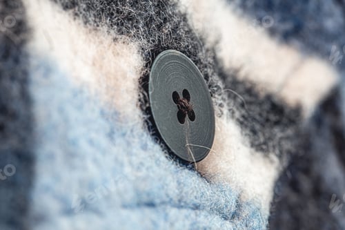 Preview: Button on a warm blue shirt, macro shot.