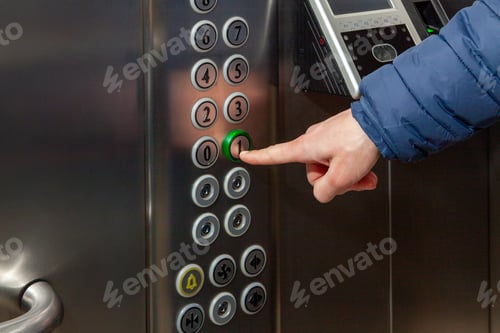 Preview: A man presses the floor button in the elevator of the business center