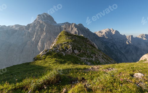 Preview: Male hiker on top of the hill looking towards the mountains