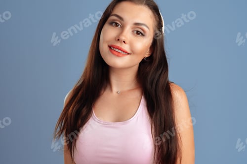 Preview: Portrait of a positive nice young woman over a gray background