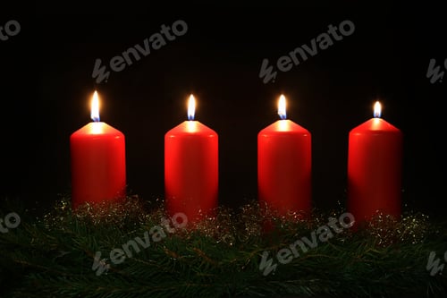 Preview: Closeup of burning red Advent candle glowing in the dark