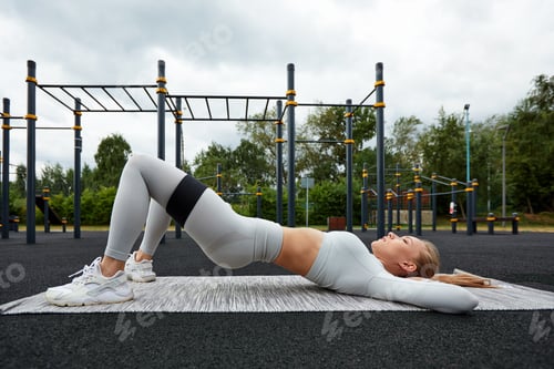 Preview: Resistance band fitness outdoors. Young athletic woman with perfect body in sportswear doing